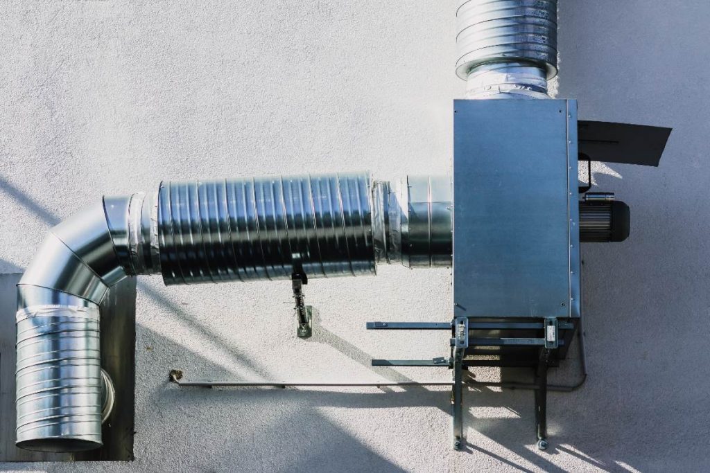 Dépose d’un ancien tuyau d’évacuation de chaudière à gaz avant remplacement