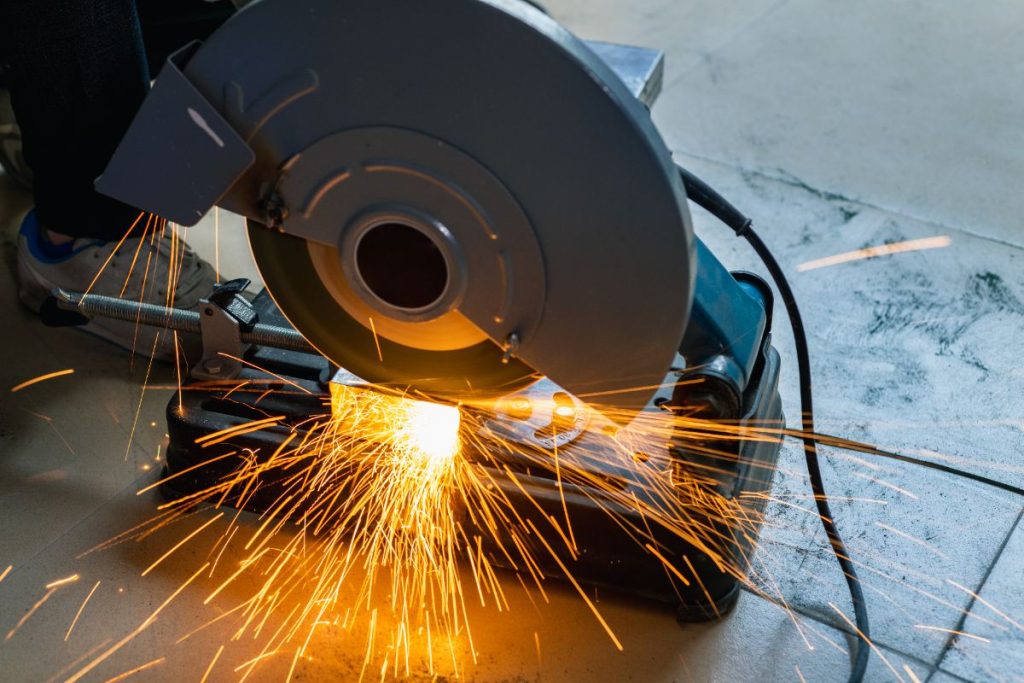 Une personne qui coupe une fonte avec un découpe de métal