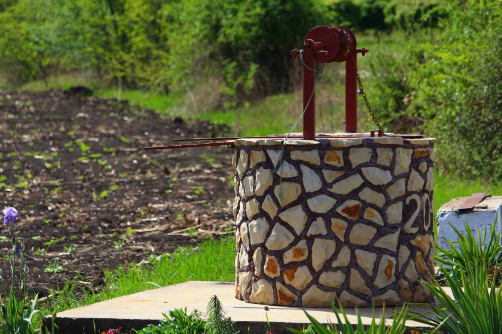 Un puits en pierre installé dans le jardin