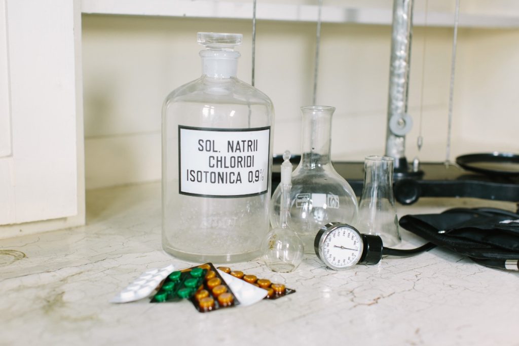 Une bouteille d'acide chlorydrique, médicaments sur table