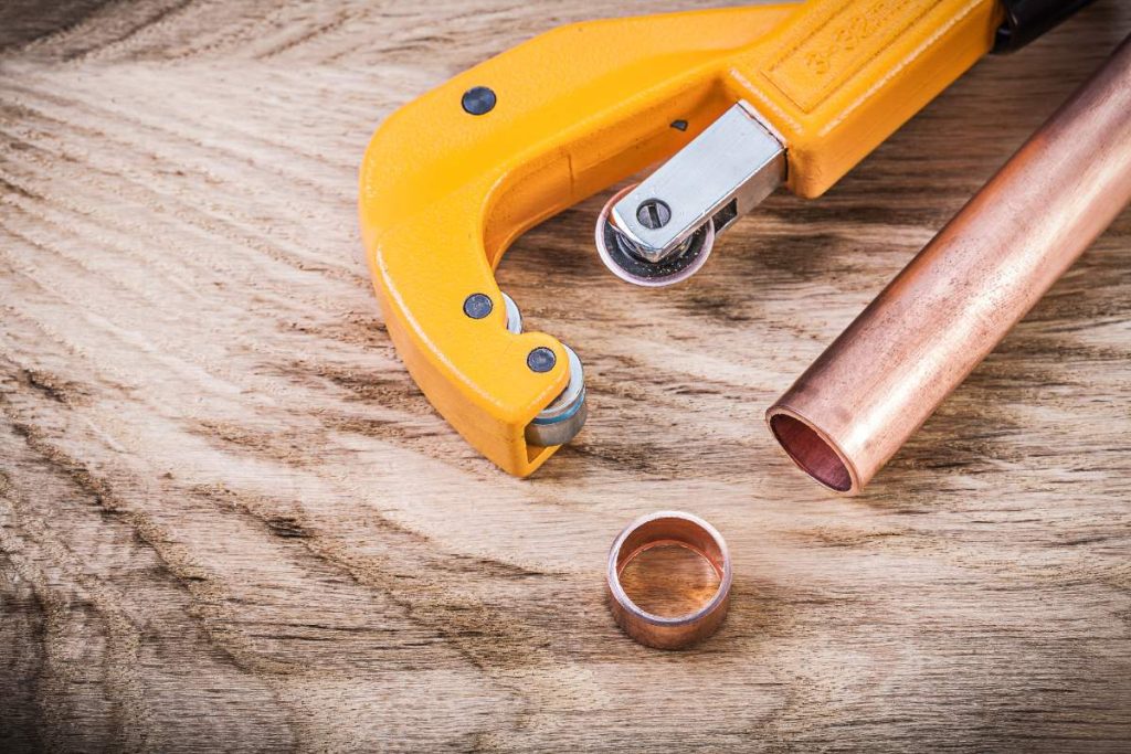 Un outil de coupe-tube, un tuyau et un anneau en cuivre