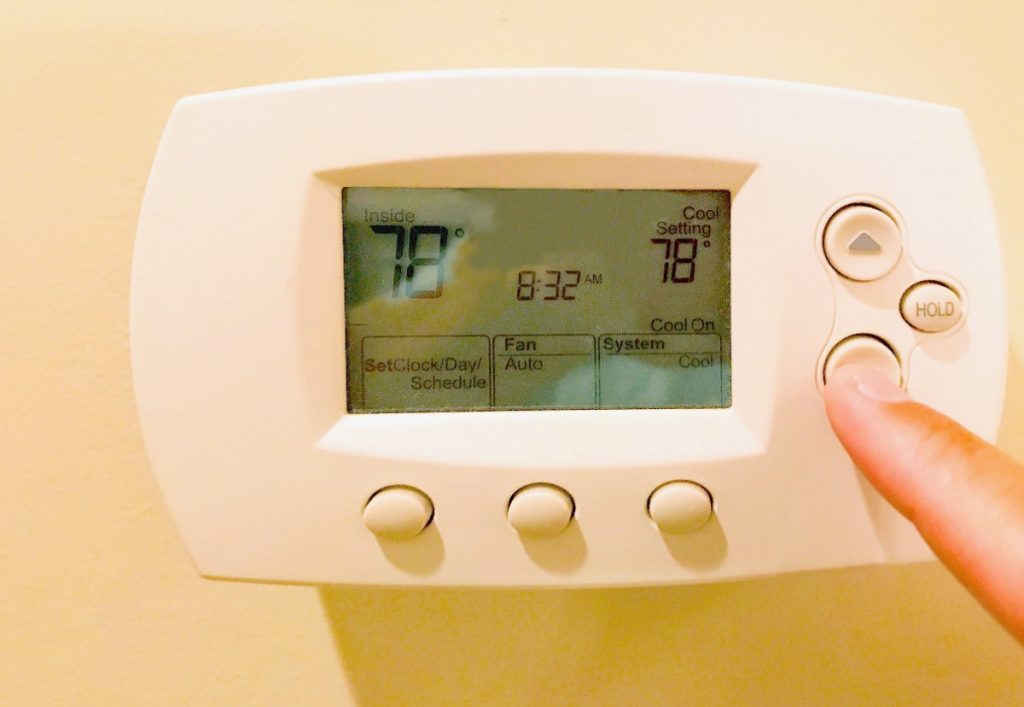 Une personne qui fait un réglage de thermostat