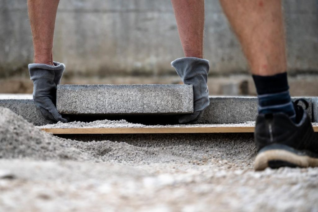 Un travailleur posant de dalle sur sable