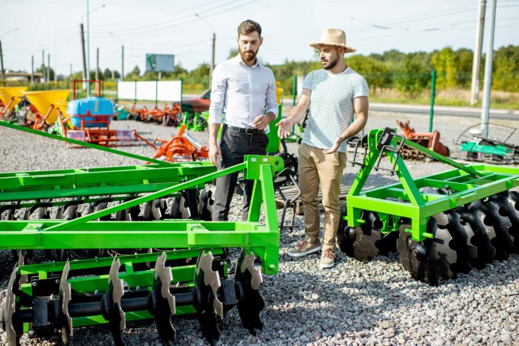 Comment construire soi-même une herse adaptée à l'entretien d'une carrière ? Un agronome qui discute avec un vendeur de matériels agricoles