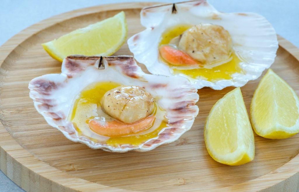 Des coquilles de Saint-Jaques poellées servies dans leurs coquilles