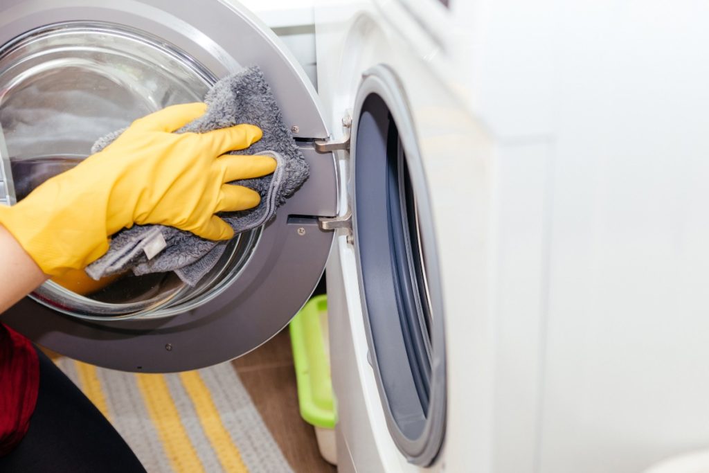Une personne nettoyant la machine à laver