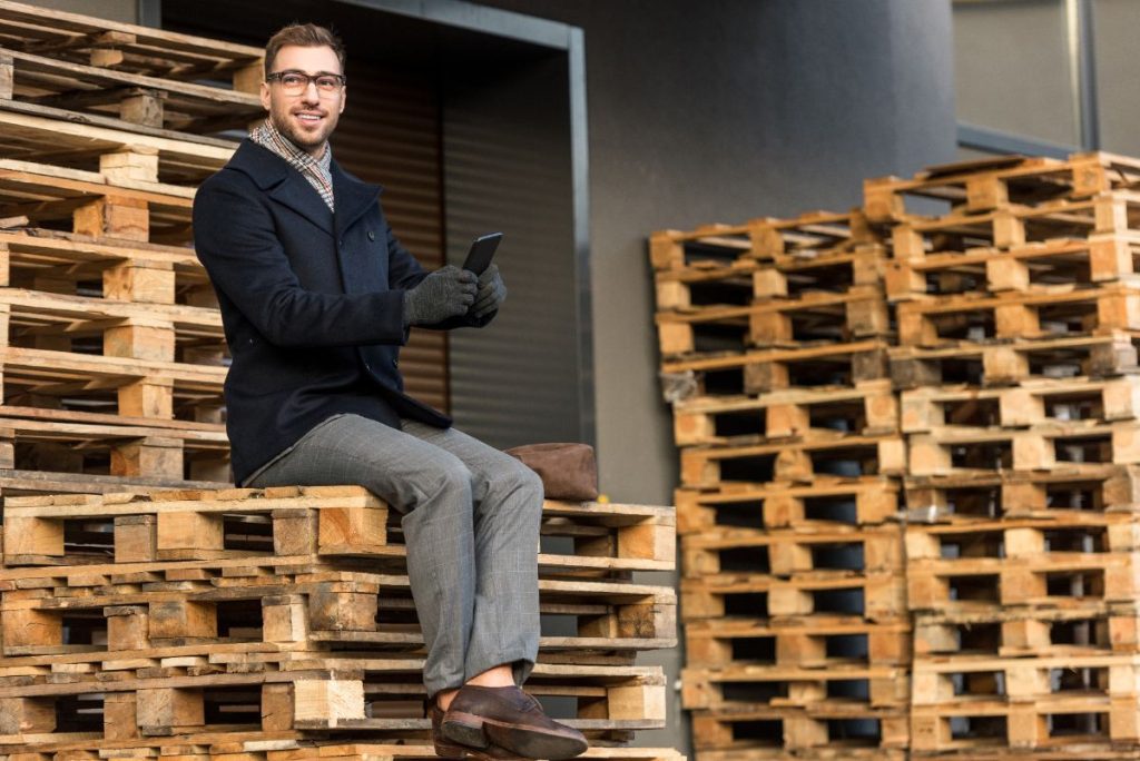 Un homme assis sur des palettes