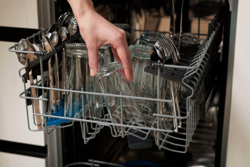 Main sortant du verre dans le lave-vaisselle