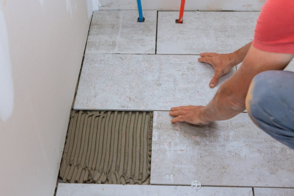 Un ouvrier installant du carrelage