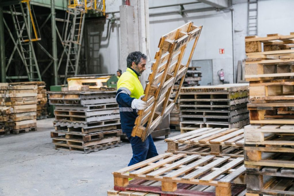 Un ouvrier transportant une palette
