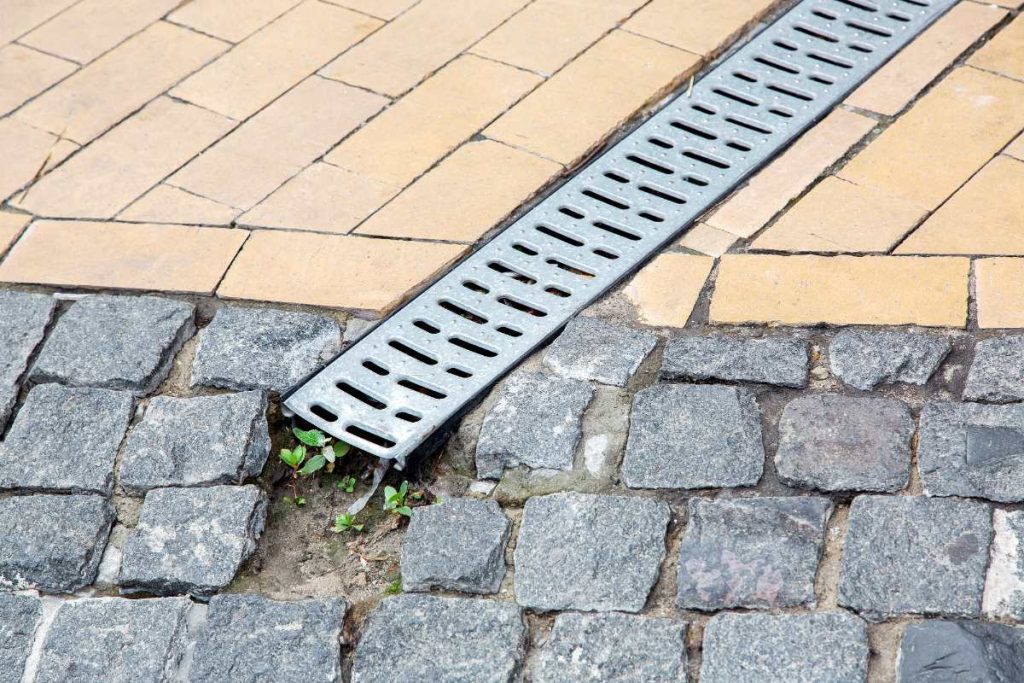 Comment installer correctement un caniveau dans votre jardin ou allée ? Un système de drainage installé dans la cours