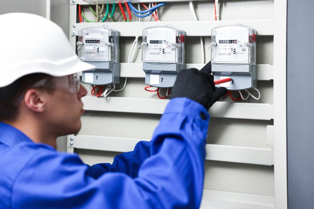 Est-il possible d'éteindre son compteur Linky et comment procéder ? Un électricien en uniforme bleu inspectant le compteur