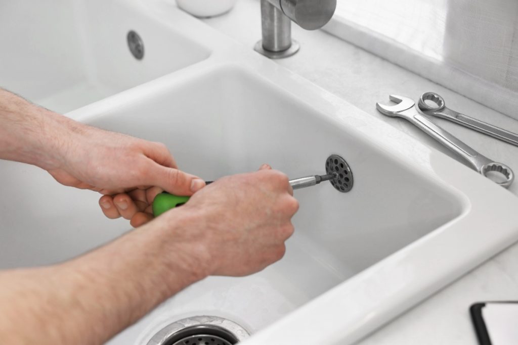Un homme qui répare une bonde de lavabo