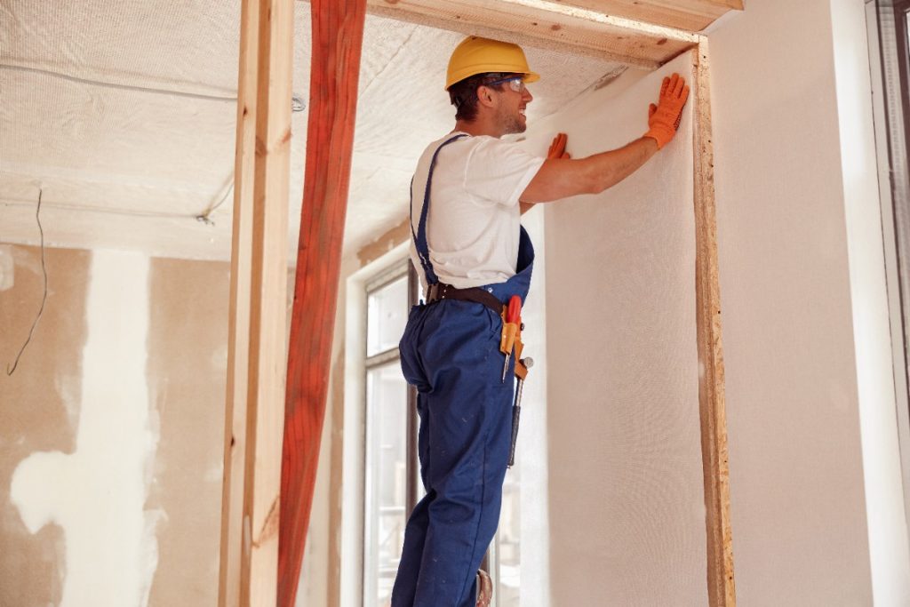 Un ouvrier installant un mur en placo