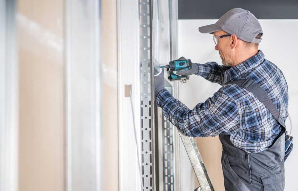 Un ouvrier installant un mur en placo