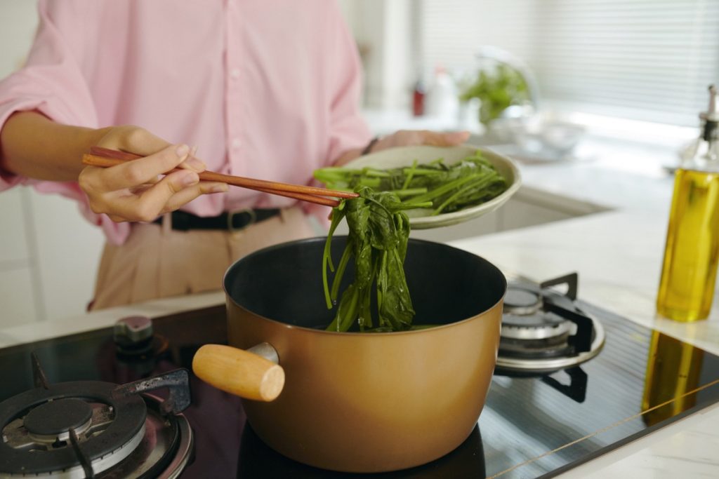 Une personne préparant des légumes verts frais