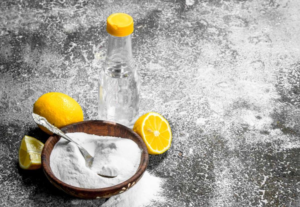 Un citron, du vinaigre et du bicarbonate de soude sur la table