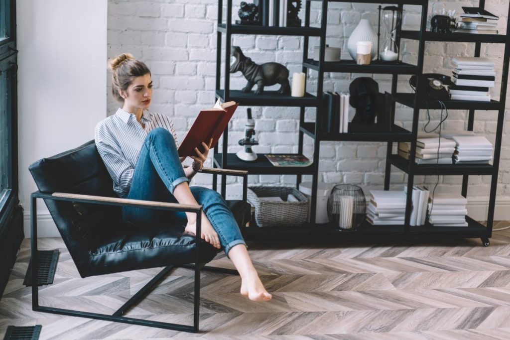 Une femme assise sur un fauteuil en lisant un livre