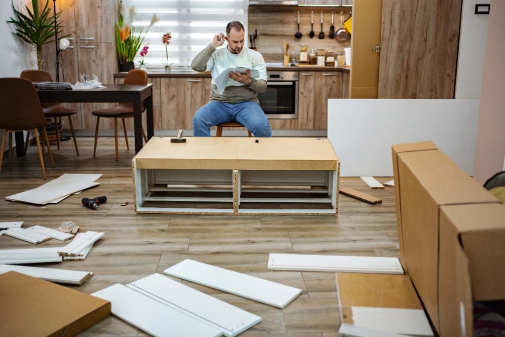 Un homme assemblant des meubles dans une maison